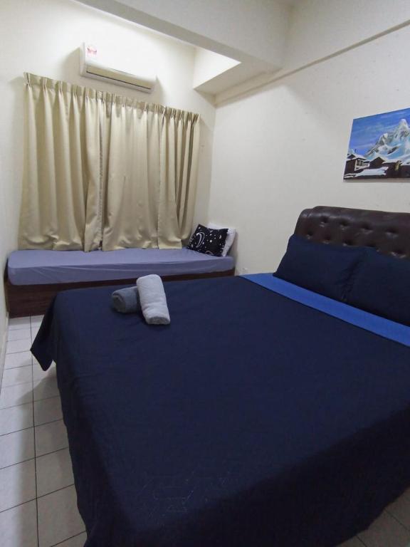 1 dormitorio con 2 camas con sábanas azules y ventana en Homestay Paradise lagoon port Dickson, en Port Dickson