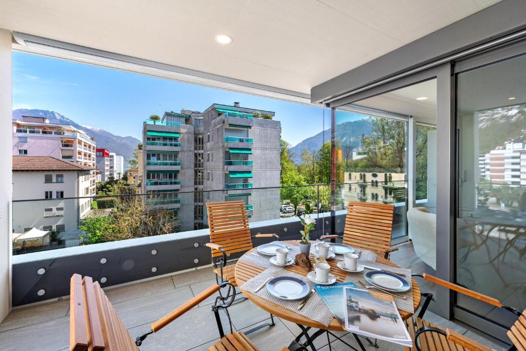 a table and chairs on a balcony with a view at Appartamento Lago e Monti - Happy Rentals in Locarno