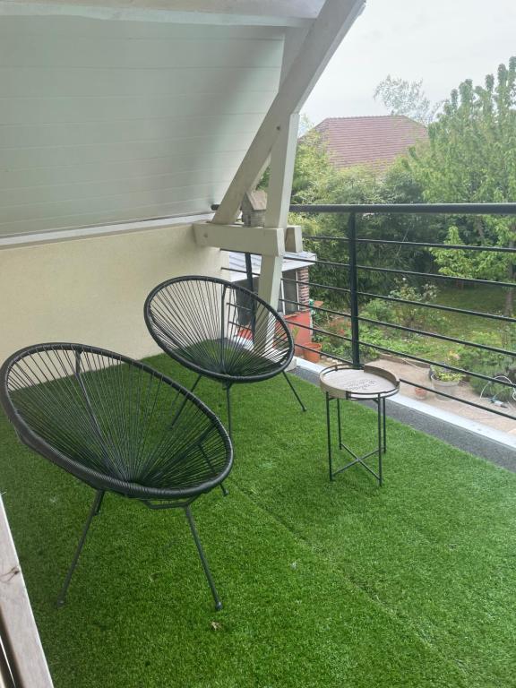 two chairs and a table on a balcony with grass at L‘Embellie in Moussey