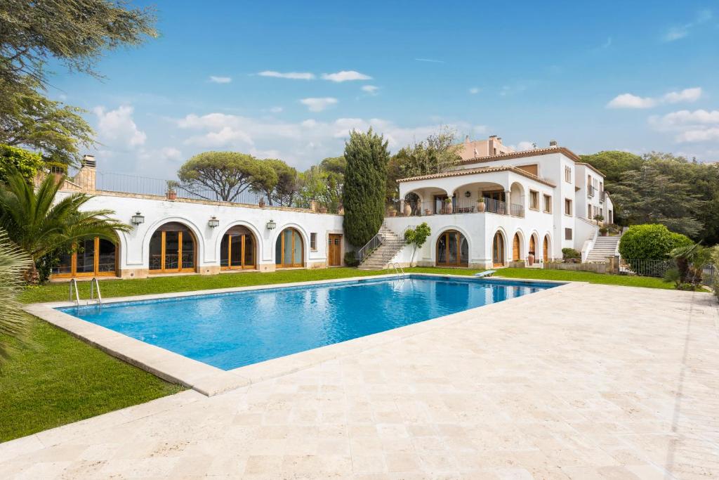 an estate with a swimming pool in front of a house at Villa Maricel in Sant Feliu de Guíxols