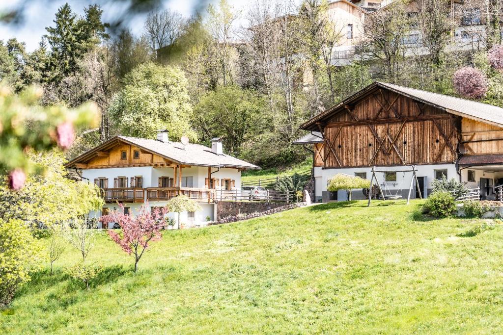 a house on a grassy hill next to a building at Apartment Misalt in Castelrotto