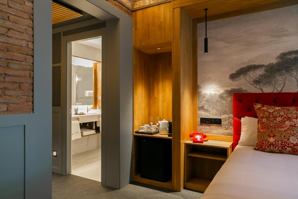 a bedroom with a bed and a bathroom at Hotel La Pau in Barcelona