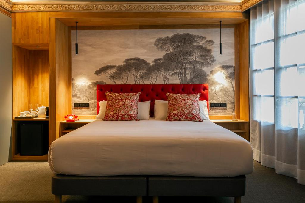a bedroom with a large bed with a red headboard at Hotel La Pau in Barcelona