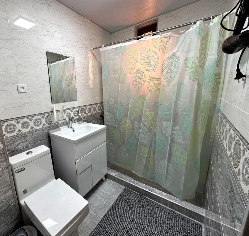 a bathroom with a shower with a toilet and a sink at Art Suzani National House Hotel in Bukhara