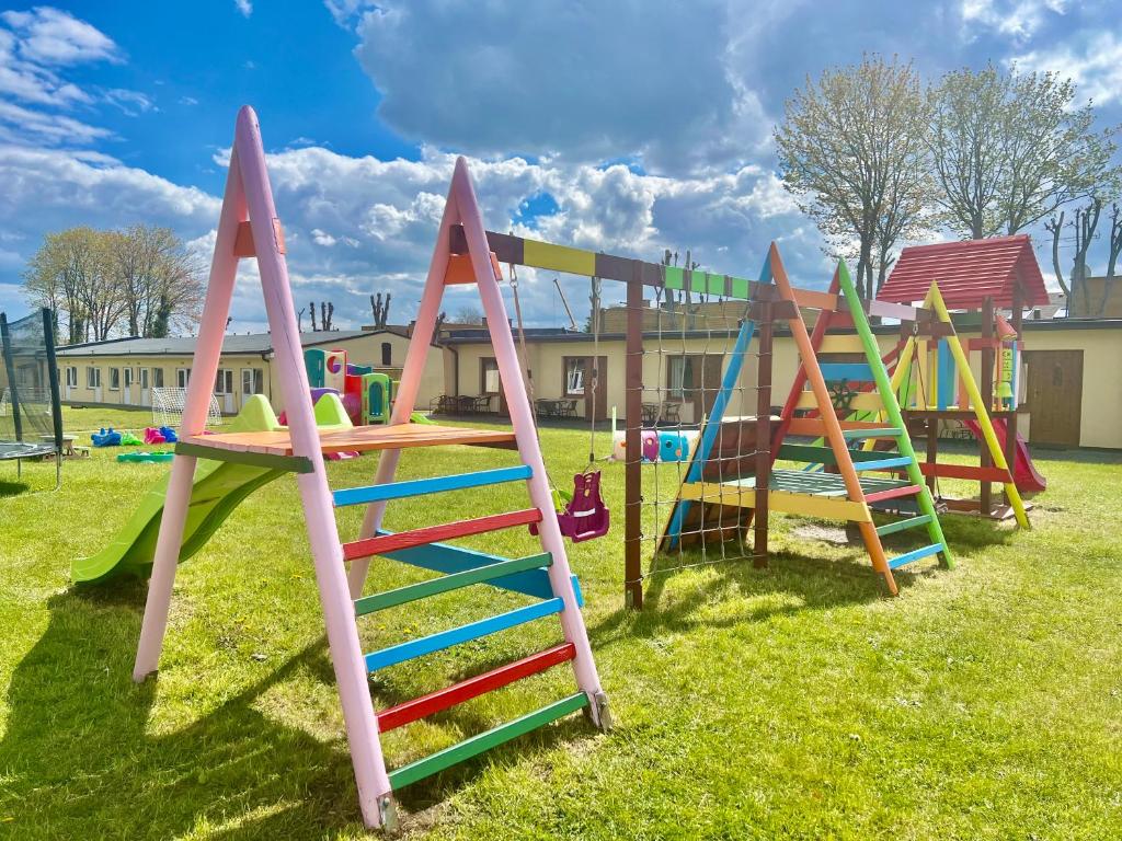 a row of colorful playground equipment in a field at Ośrodek "Pod Wydmami" in Sarbinowo