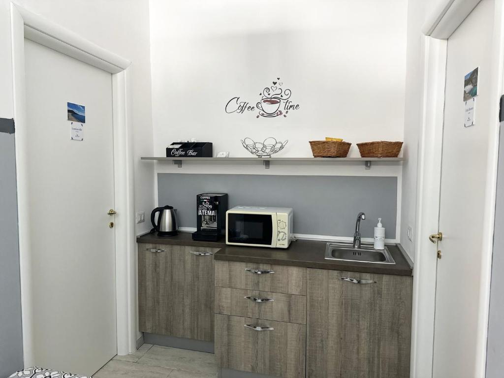 eine Küche mit einer Spüle und einer Mikrowelle auf der Theke in der Unterkunft Mareluna Bed and Breakfast in Marina di Camerota