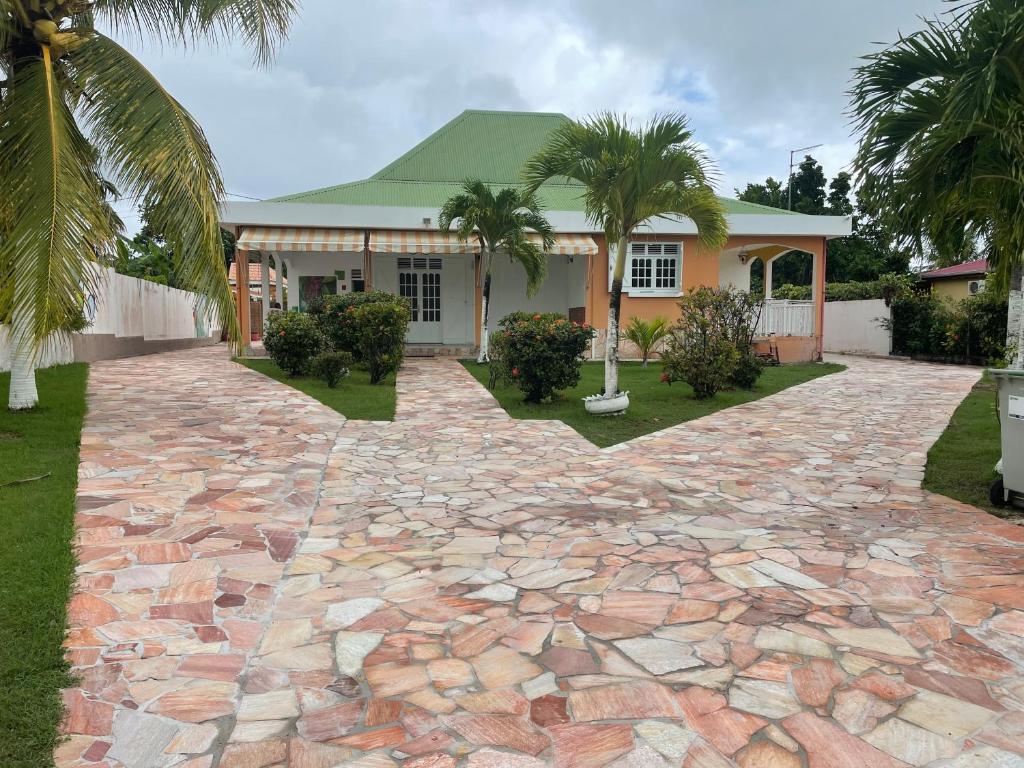 a house with a stone driveway in front of it at Villa Guadeloupe standing in Le Moule
