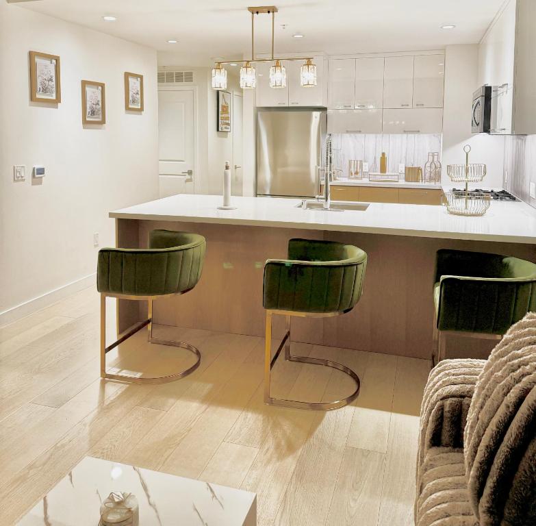 a kitchen with two green bar stools and a counter at Relax On The Penthouse Floor DTLA With A View in Los Angeles