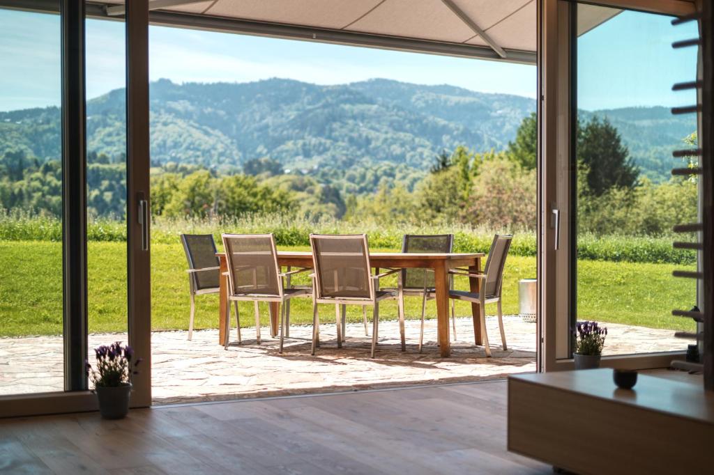 una mesa y sillas con vistas a las montañas en Traumhaftes Ferienhaus am Lateinberg - 8455 Eibiswald Südsteiermark, en Eibiswald