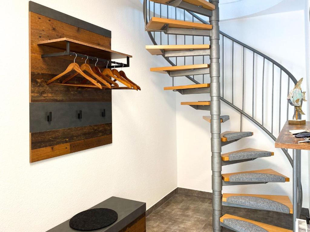 una escalera en una casa con zapatos en la pared en Kormoran 19, en Zingst