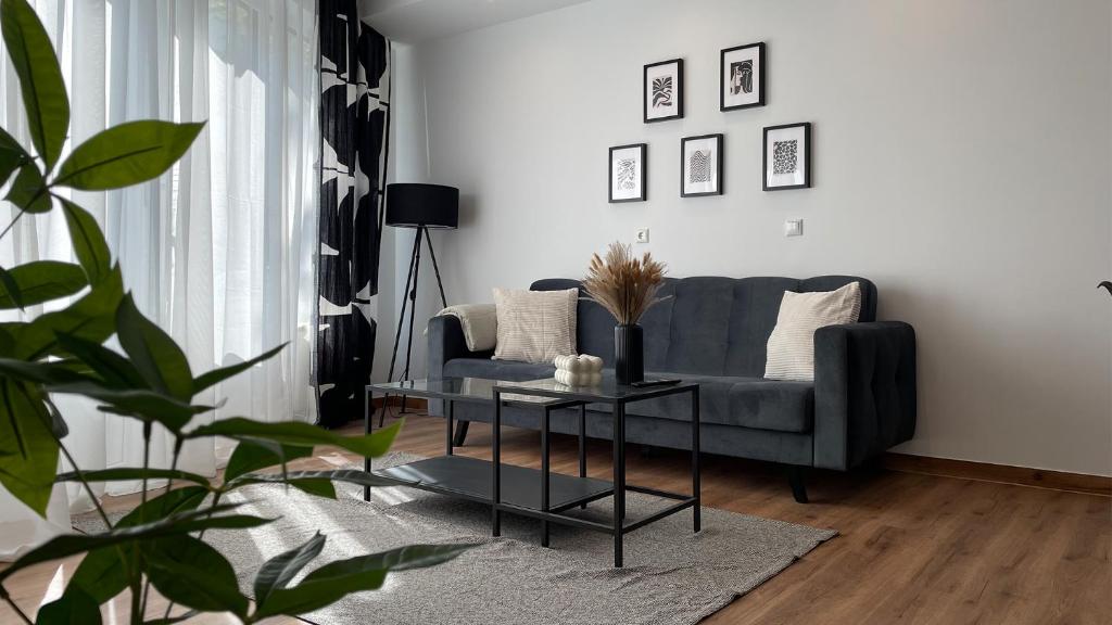 ein Wohnzimmer mit einem Sofa und einem Tisch in der Unterkunft Gallery Apartment in Bonn