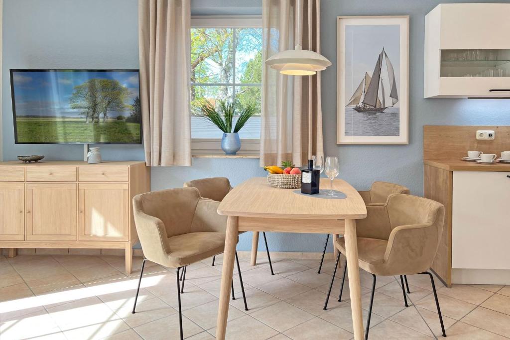 een keuken met een tafel en stoelen en een televisie bij Sonnenschein in Zingst