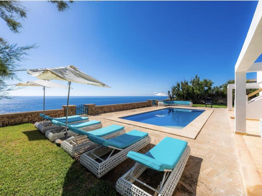 a swimming pool with lounge chairs and an umbrella at Domus Alba A in Portocolom