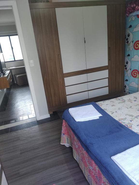 ein Schlafzimmer mit einem Bett und einer Schiebetür in der Unterkunft Quarto com banheiro privativo in Balneário Camboriú