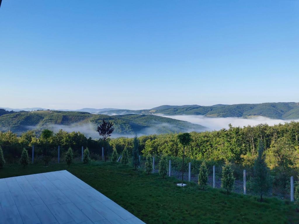 a room with a view of a valley with fog in the hills at Villa Arisi in Pristina