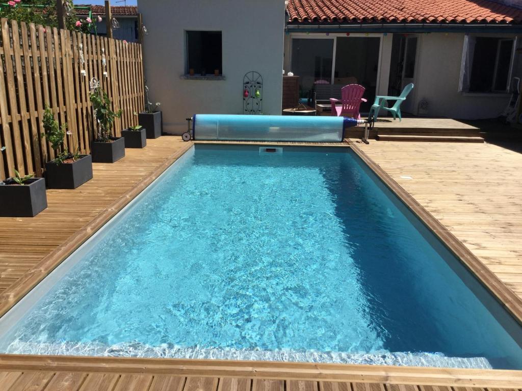 une piscine avec une terrasse en bois et une piscine dans l'établissement Maison pour 6 pers avec piscine à Bordeaux, à Bègles