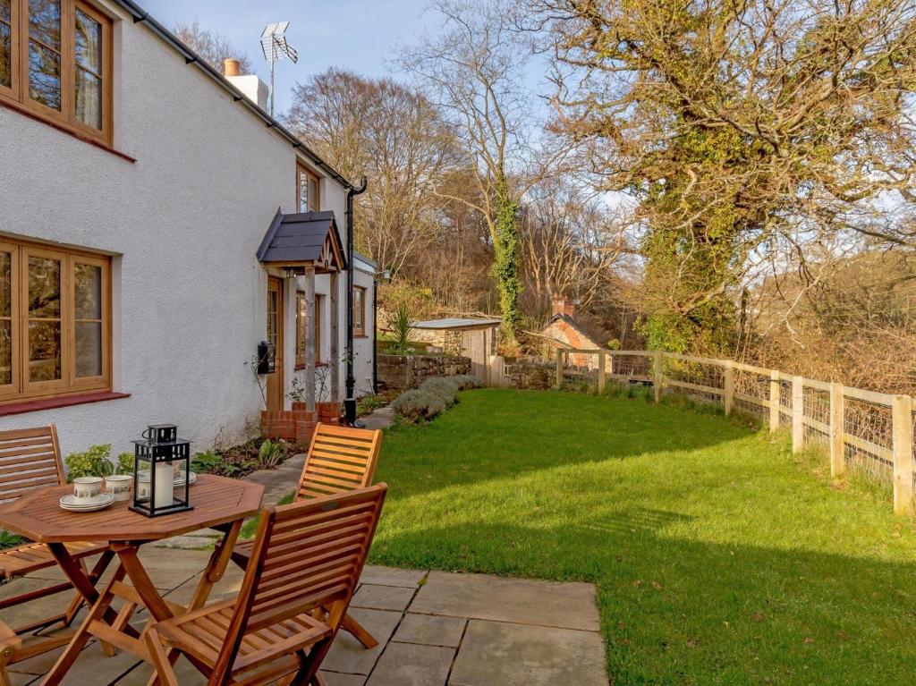 a patio with a table and chairs and a yard at 2 Bed in Lydbrook 55961 in Lydbrook
