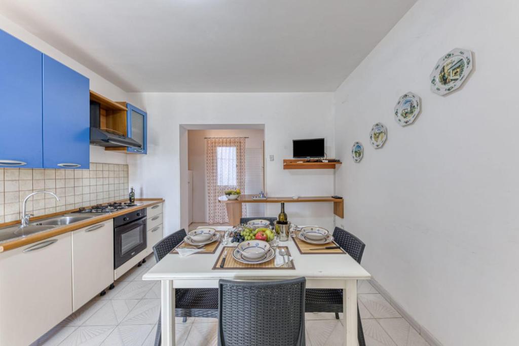 cocina con mesa y sillas en una habitación en Casa Trilussa Trilocale by Salento com, en Torre Mozza