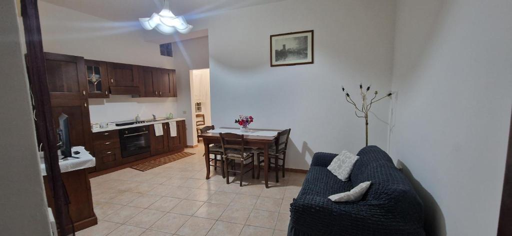 a living room with a blue couch and a kitchen at Casa Grilla in Assemini