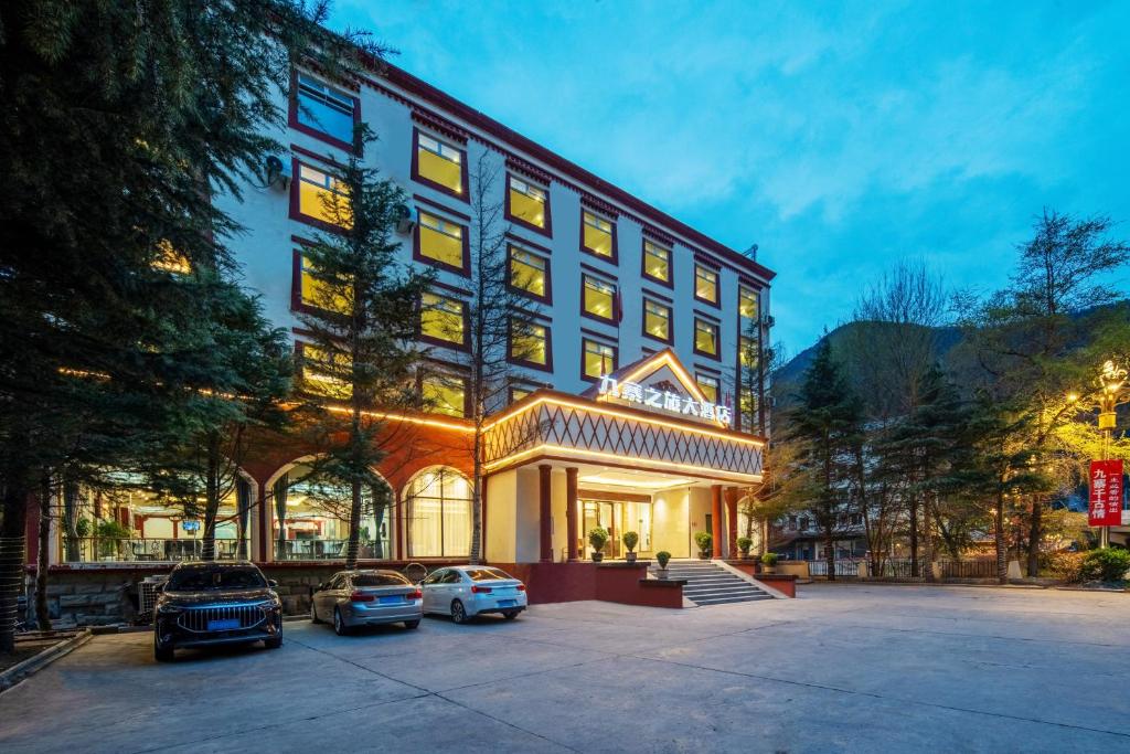 a hotel with cars parked in front of it at Jiuzhai Journey Hotel in Jiuzhaigou