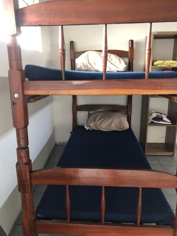 - un lit superposé avec un oreiller bleu sur la couchette inférieure dans l'établissement Hostel Vegaspub1600 Experiência, à Campina Grande