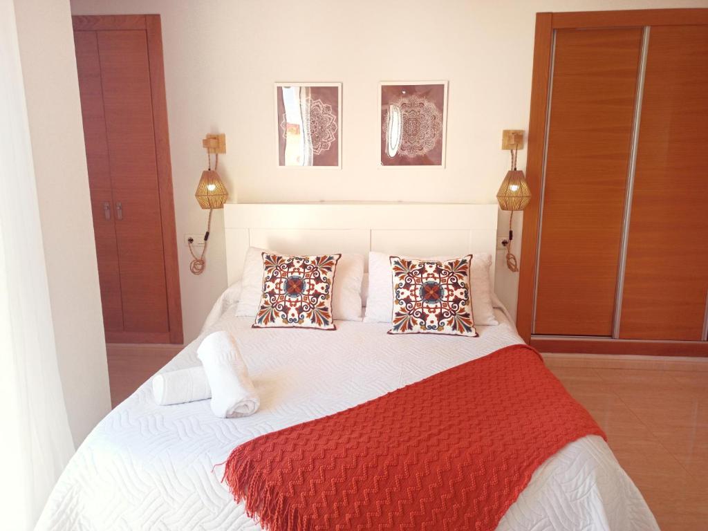 a bedroom with a white bed with two pillows at Avenida Principal - Gran Terraza junto a la playa - by Aloha Palma in Águilas