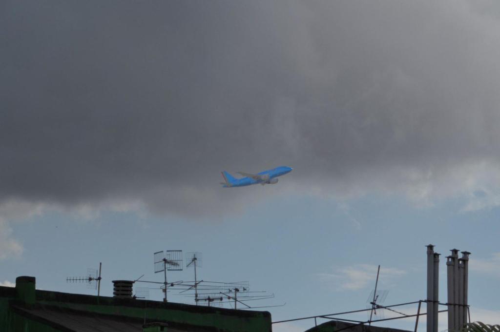 un avión volando en el cielo sobre un edificio en Flyway en Nápoles