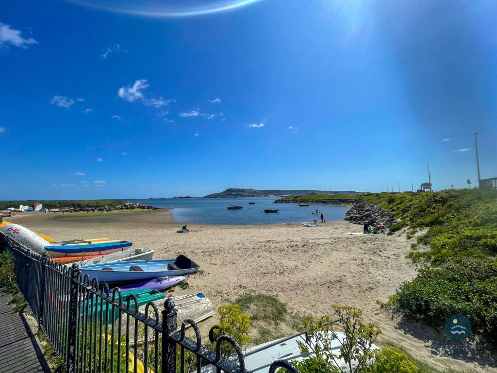 a beach with boats sitting on the sand at Spindrift - views of Chesil beach dog friendly in Weymouth