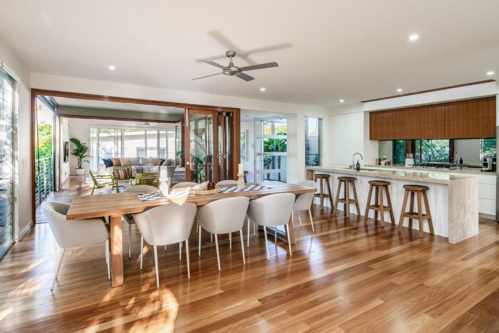 a kitchen and dining room with a wooden table and chairs at Headlands Hideaway - Pet Friendly Home at Moffs in Caloundra