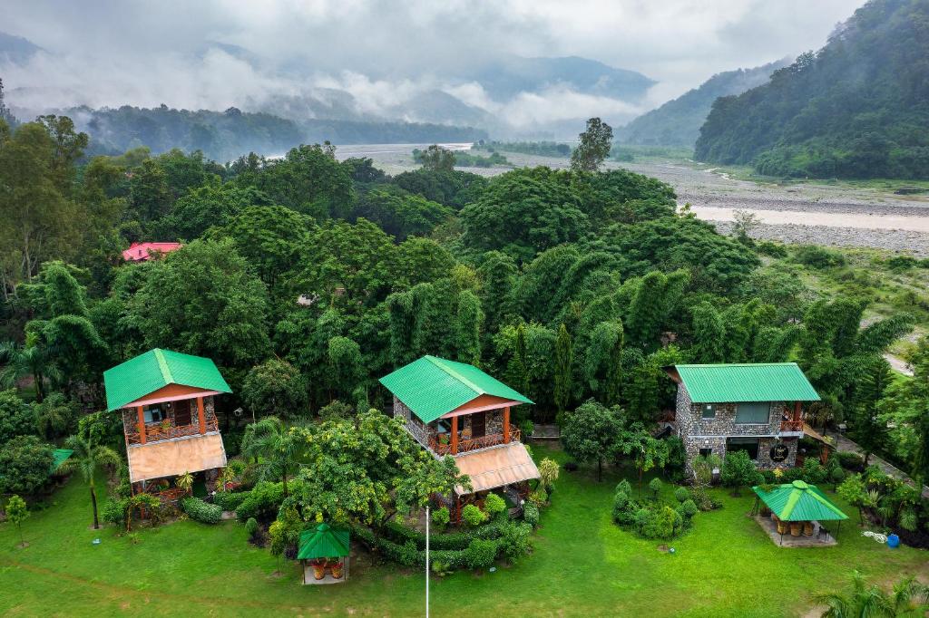 Marchula的住宿－Tashree Kabeela Riverside Resort，两栋带绿色屋顶的房屋的空中景致