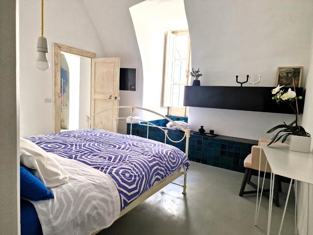 a blue and white bedroom with a bed and a table at Capri Kronos GuestHouse in Anacapri