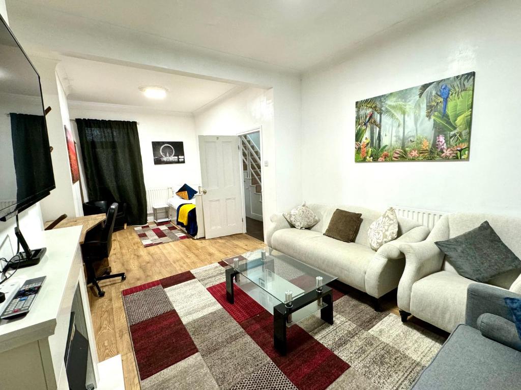 uma sala de estar com um sofá e uma mesa em 4 Bedrooms, 2 Bathrooms, Parking, Spacious House em Londres