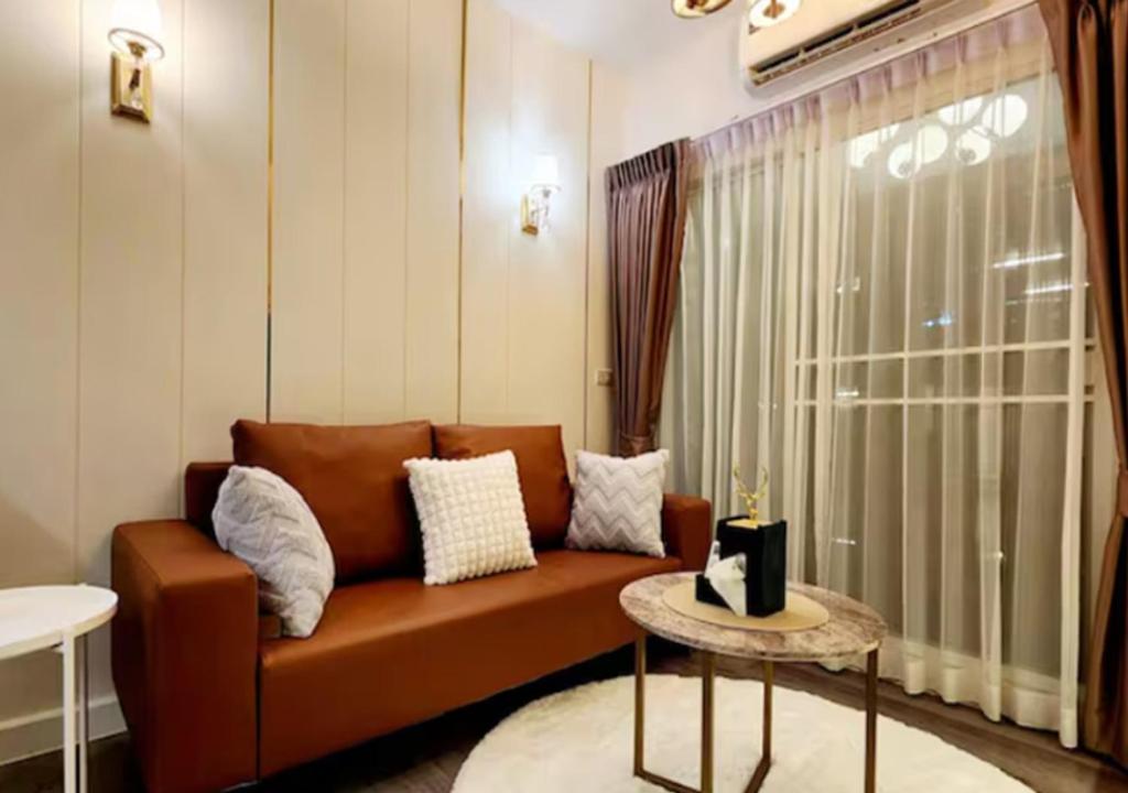 - un salon avec un canapé brun et une fenêtre dans l'établissement 20 Chatuchak market,Night market, Bts, à Ban Khi Sua