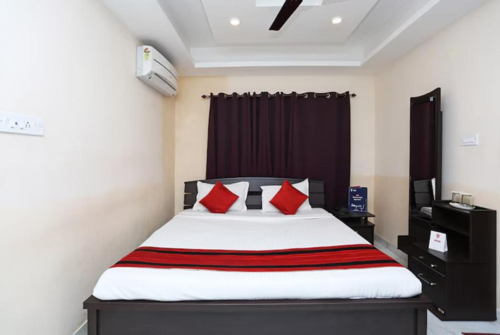 1 dormitorio con 1 cama grande con almohadas rojas en Goroomgo White Palace Hotel & Resort New Alipore Kolkata - Fully Air Conditioned en Calcuta