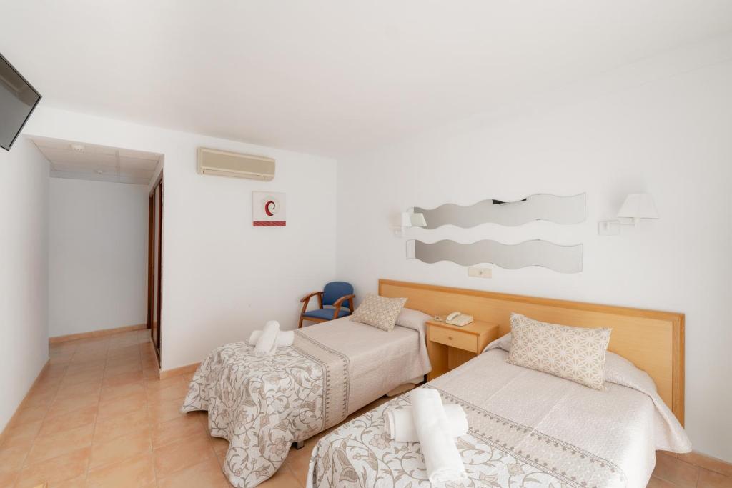 a bedroom with two beds and a desk and a table at Hotel Santa Faz in Benidorm