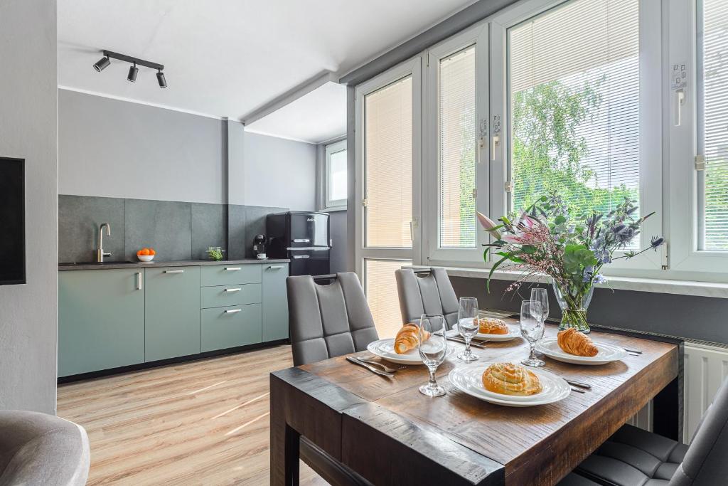 eine Küche und ein Esszimmer mit einem Tisch mit Essen drauf in der Unterkunft P&O Apartments Gierymskiego in Warschau
