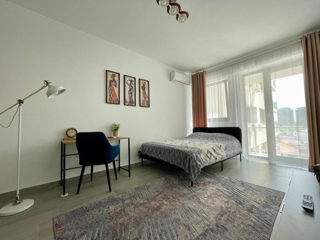a bedroom with a bed and a desk and a chair at BELVEDERE Apartments in Bucharest