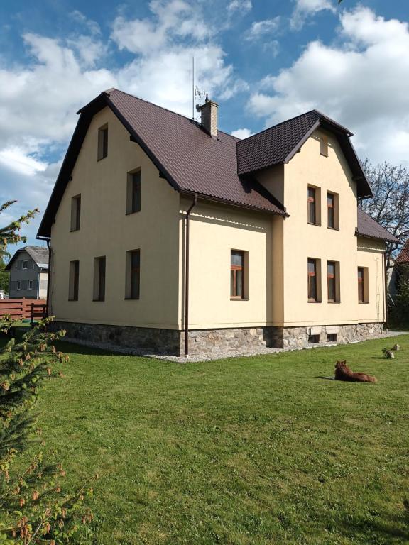 una gran casa blanca con techo negro en Vila Pavlínka , apartmány Losiny, en Velké Losiny