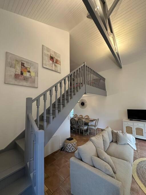 un salon avec un canapé et un escalier dans l'établissement Magnifique mas provençal avec piscine au centre de Goudargues, à Goudargues