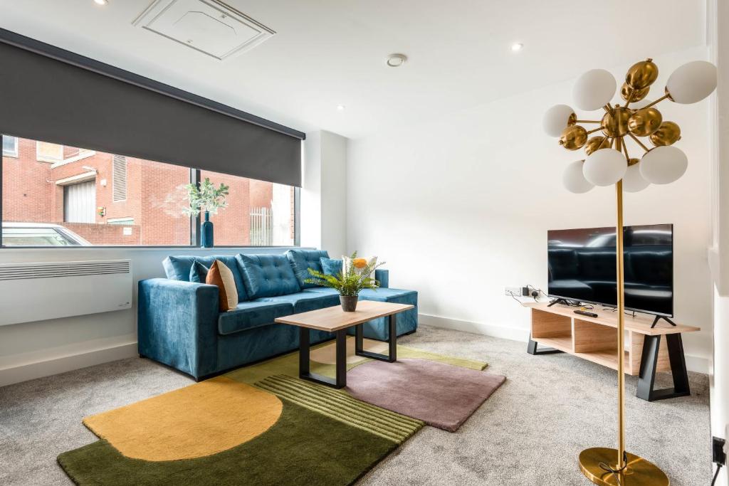 a living room with a blue couch and a tv at Modern Studio Apartment in Central Rotherham in Rotherham