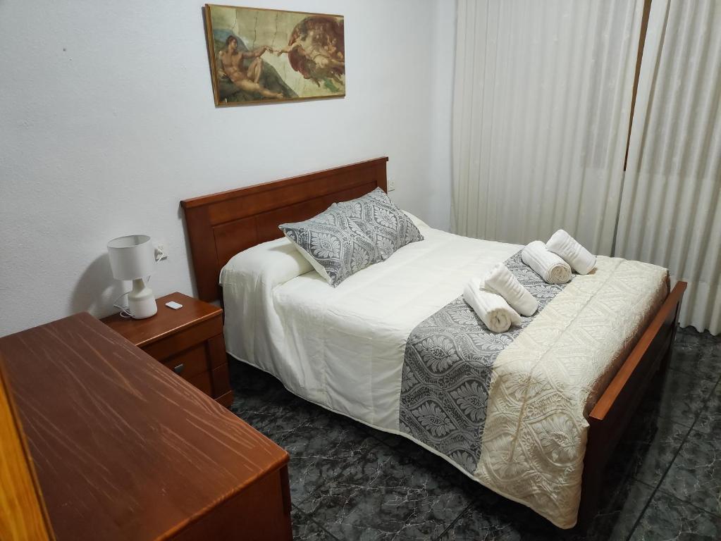 um pequeno quarto com uma cama e uma mesa em Casa del Castillo em Caravaca de la Cruz
