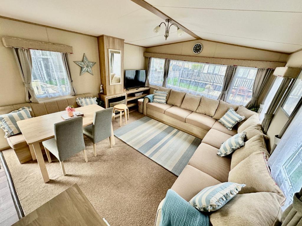 Everton的住宿－Coastal Retreat a gorgeous 3 bedroom Caravan B46，客厅配有沙发和桌子