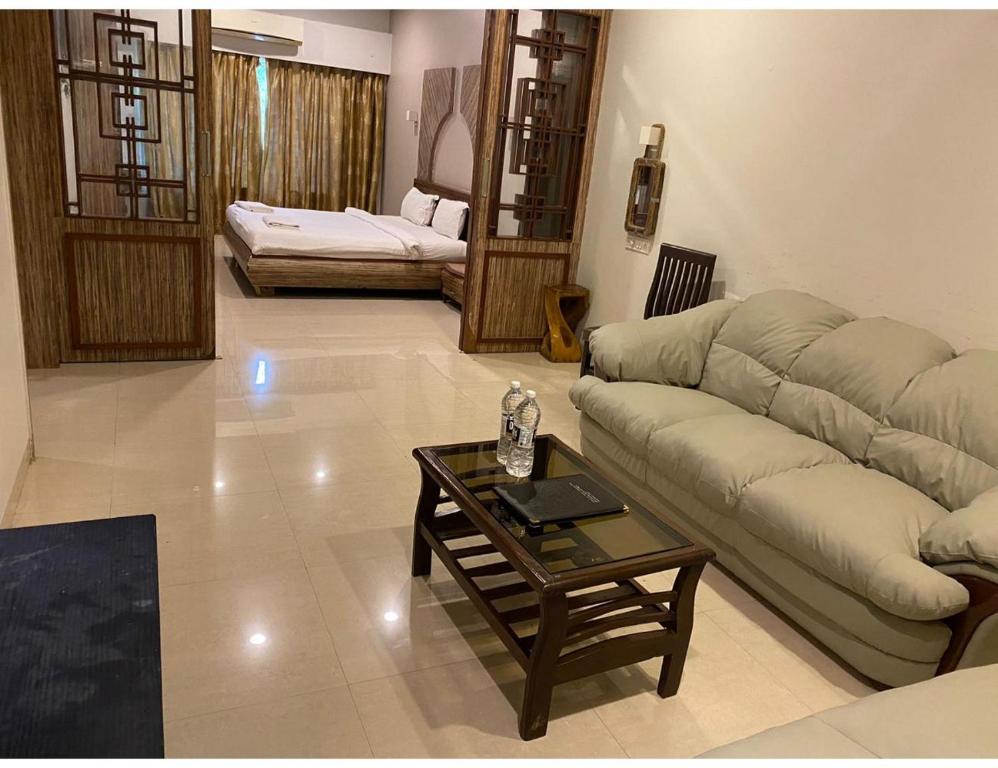 a living room with a couch and a coffee table at Hotel Rishivan Resort, Khopoli in Khopoli