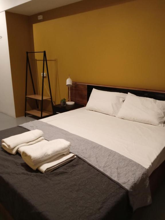 a bedroom with a large bed with two towels on it at Central Hostel in Athens
