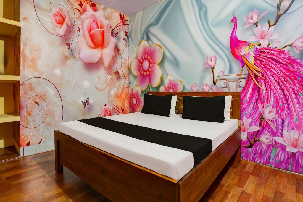 una camera da letto con un letto con un murale di pavoni di OYO WELCOME GUEST HOUSE a Rudrapur