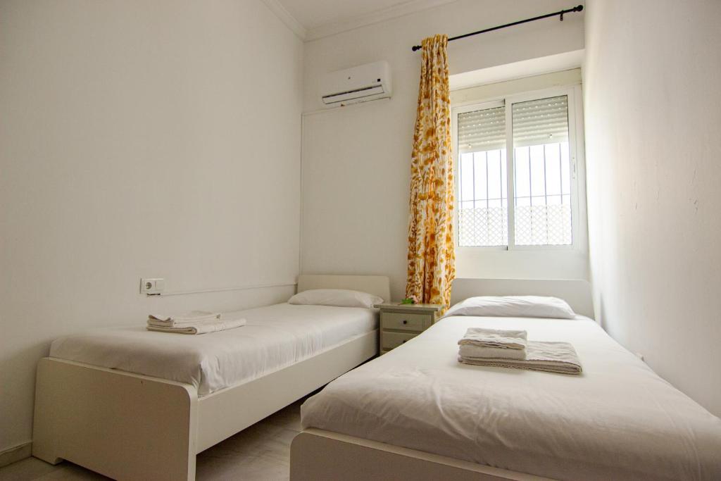 Łóżko lub łóżka w pokoju w obiekcie RentalSevilla Apartamento encantador en el Gran Poder