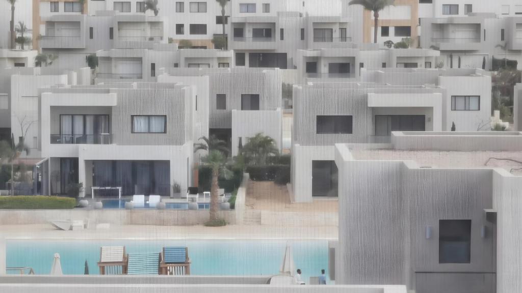 a group of white buildings with a swimming pool at Sand Castle Villa Azha - 2 bedrooms - Next Tanoak Hotel in Ain Sokhna