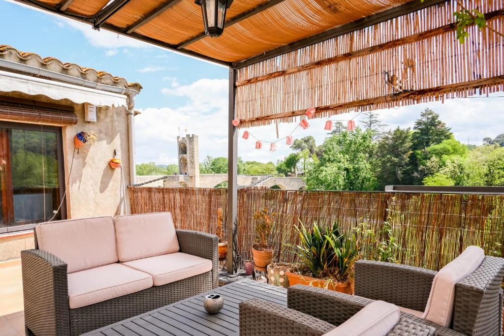 un patio con sillas de mimbre y una mesa en El mirador del pont en Besalú