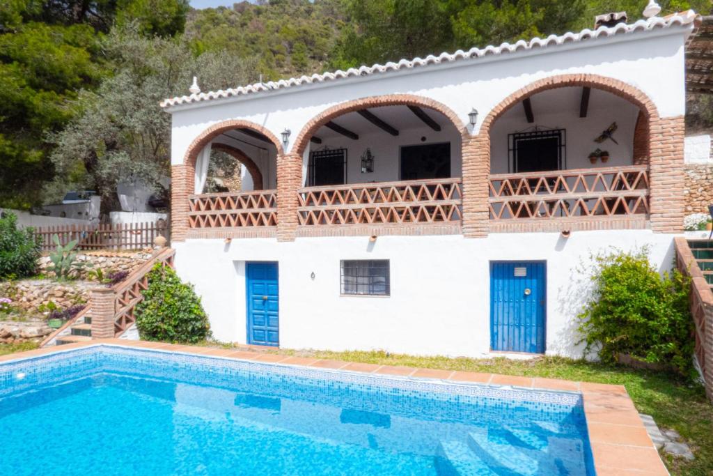 une villa avec une piscine en face d'une maison dans l'établissement Cortijo Fernando, à Frigiliana