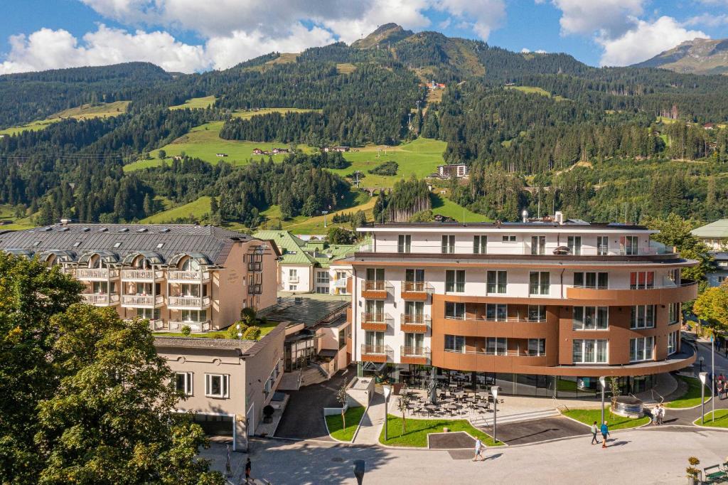 an apartment building in a town with mountains in the background at Aktiv- & Gesundheitsresort das GXUND in Bad Hofgastein